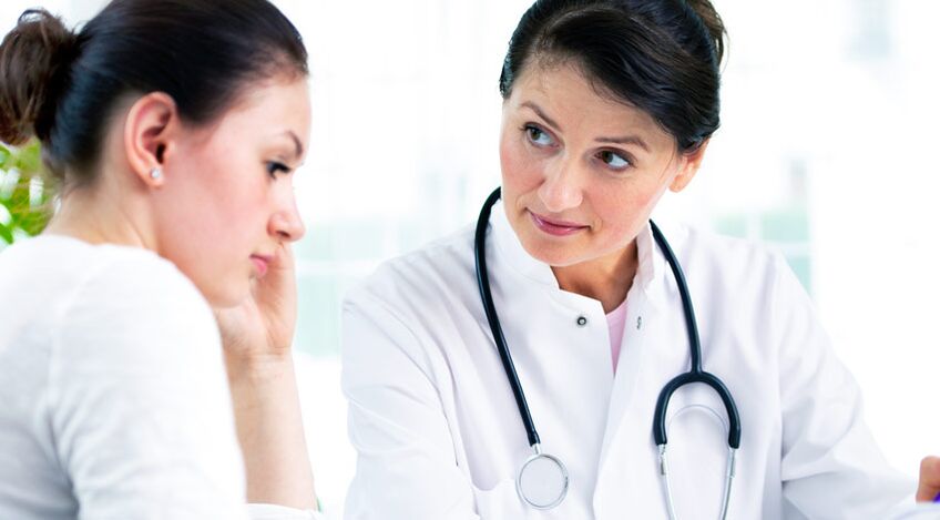 Zdravnik svetuje pacientu o indikacijah za augmentacijsko mamoplastiko.